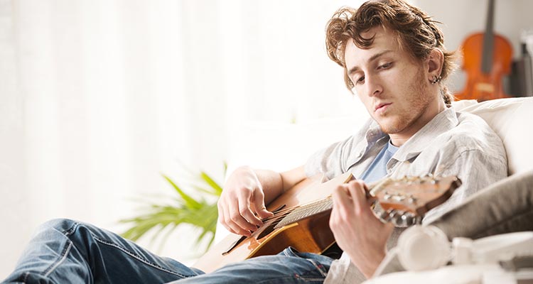 Songwriter Composing A Song On Acoustic Guitar