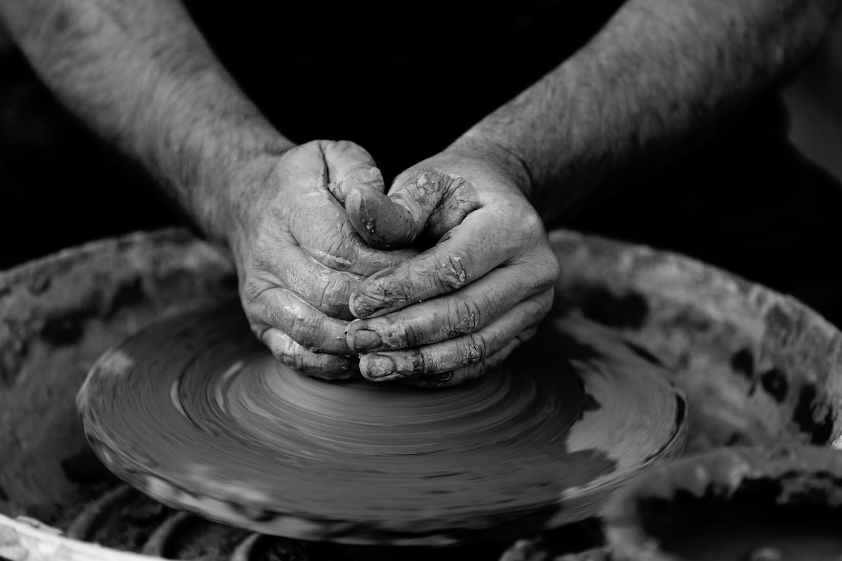 Why make art? Hands on a potter's wheel.
